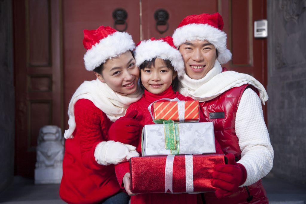 Family holding gifts dressed in holiday attire