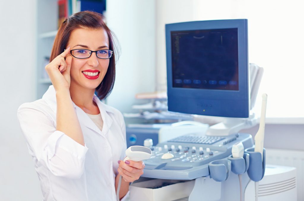 cheerful female ultrasound tech with ultrasound sensor