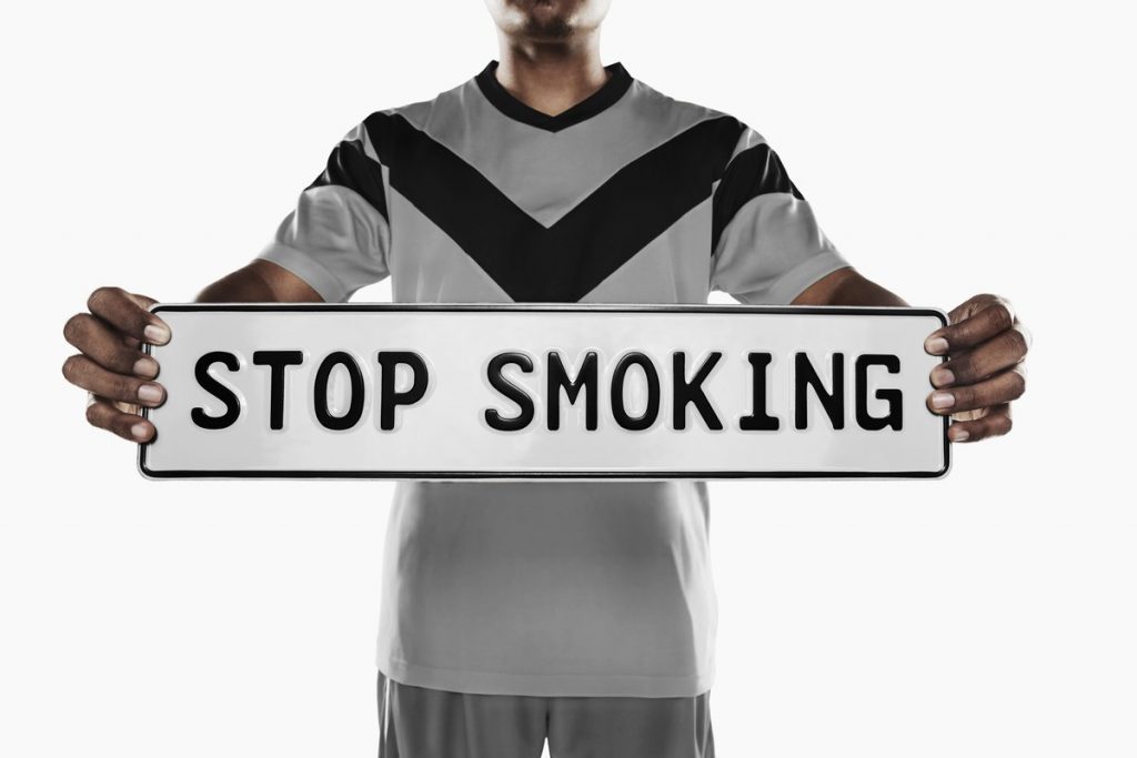 Man holding a sign that says "Stop Smoking"