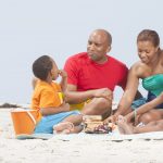 Family sitting together on a blanket at the beach