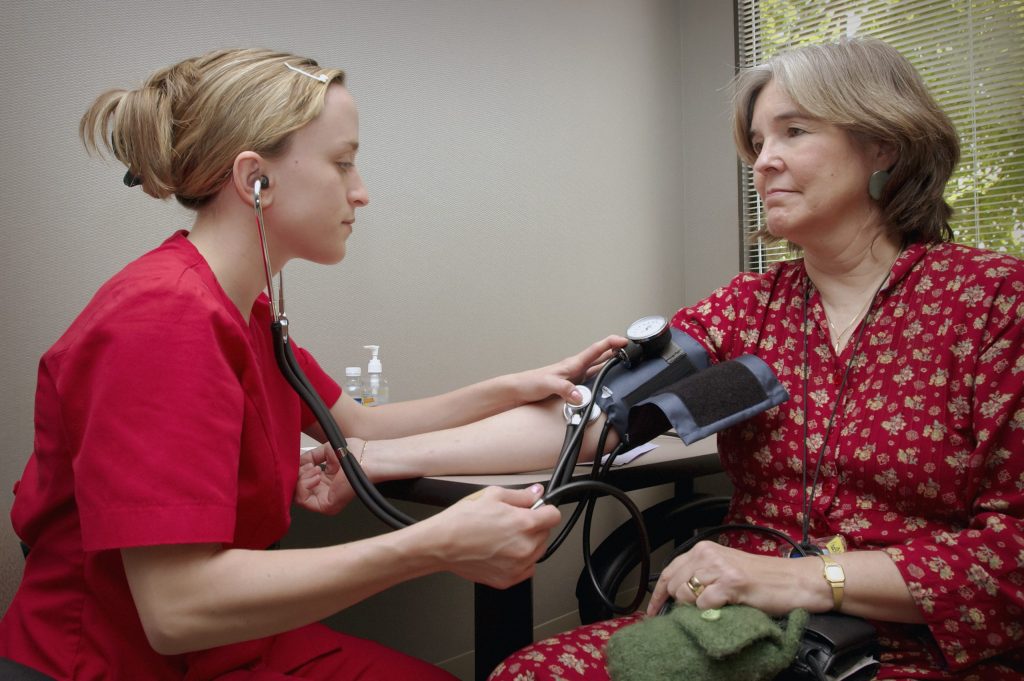 Woman getting her blood pressure checked at a doctor's office