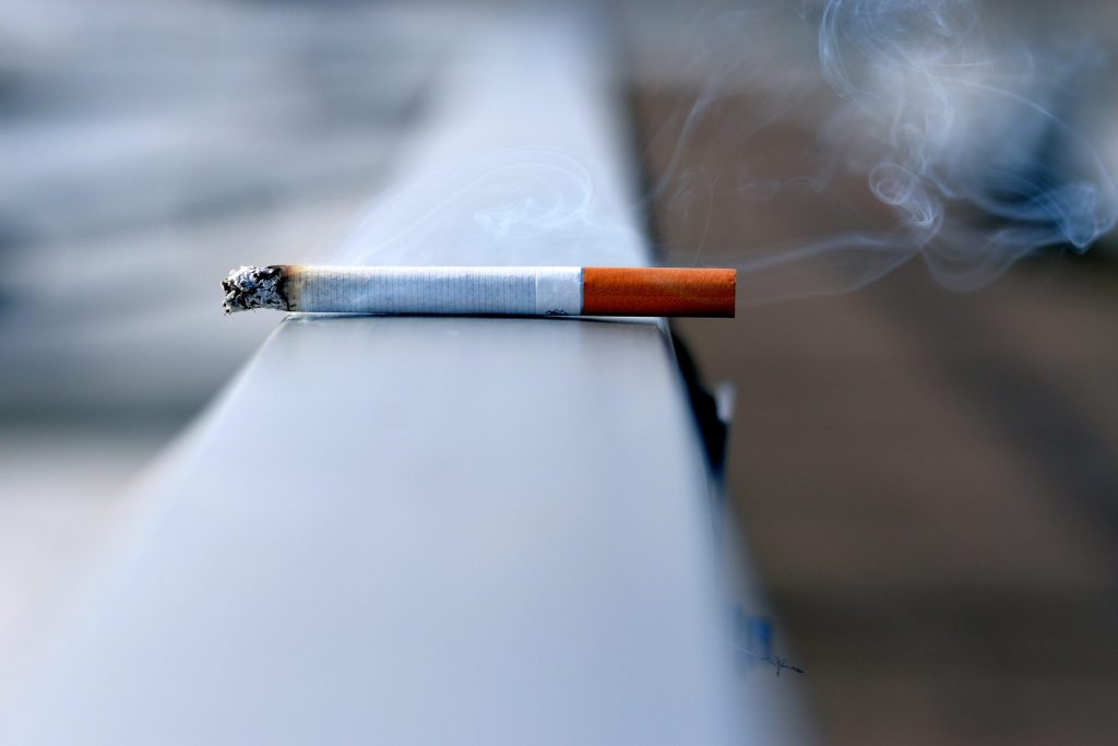 lit cigarette left on a ledge burning